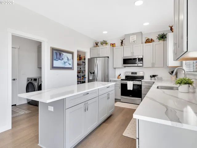 a kitchen with stainless steel appliances sink and white cabinets