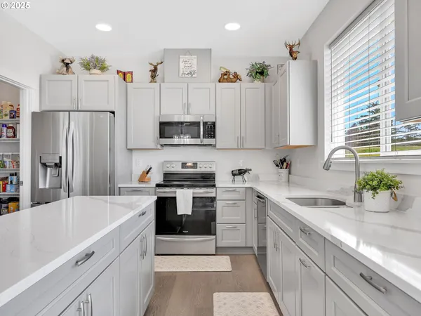 a kitchen with white cabinets and stainless steel appliances