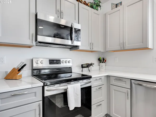 a kitchen with white cabinets and appliances