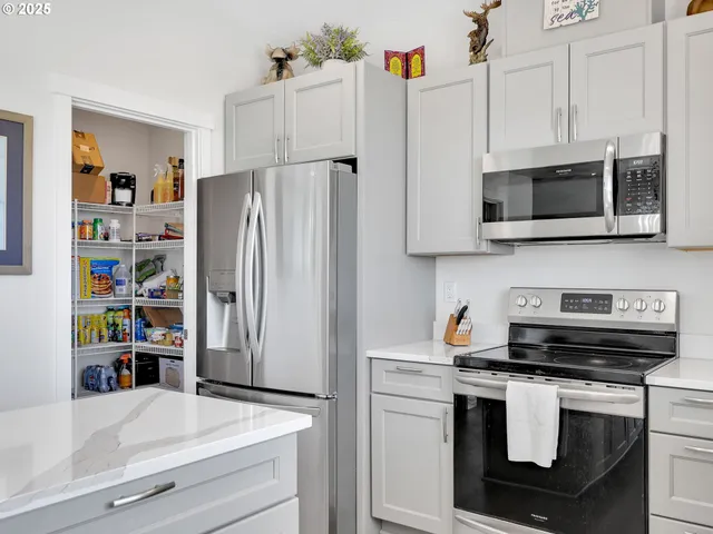 a kitchen with stainless steel appliances a refrigerator stove and microwave