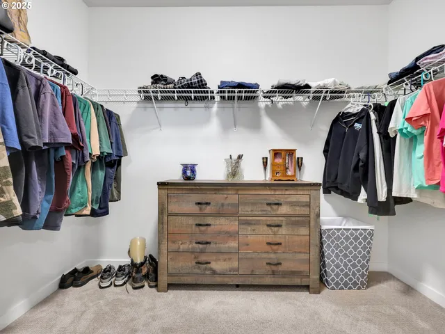 a view of walk in closet with clothes and shoes