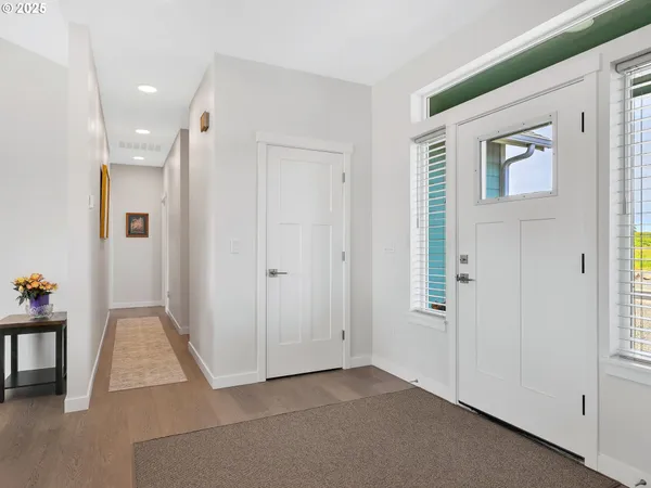 an entryway space with wooden floor and windows