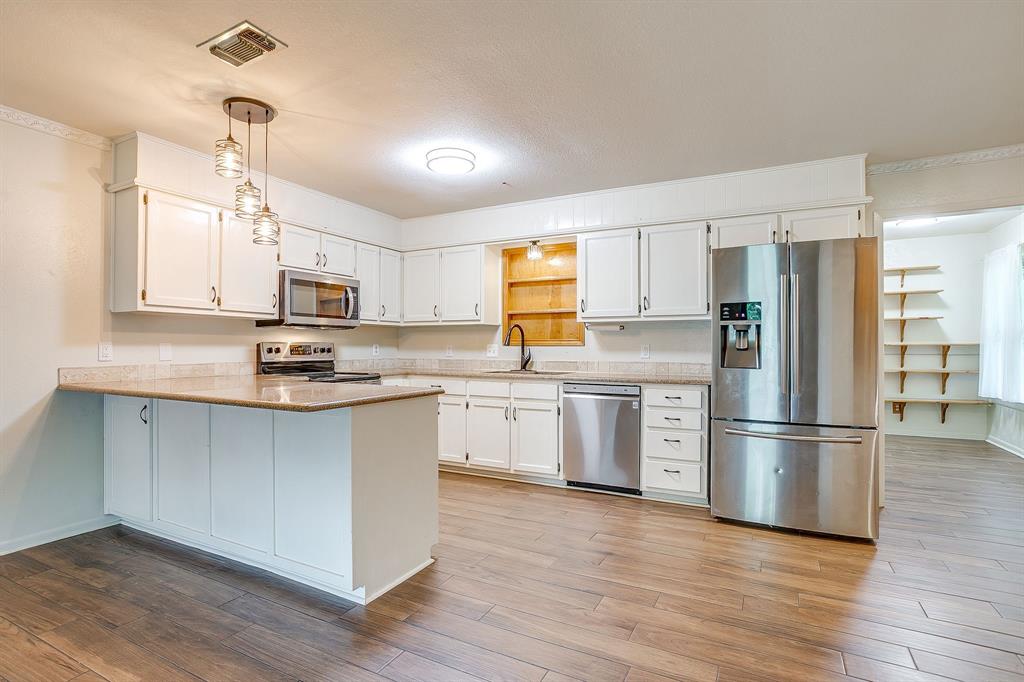 709 North Ave B Springtown, TX 76082 - Photo 10 of 32 a kitchen with stainless steel appliances a refrigerator sink and microwave