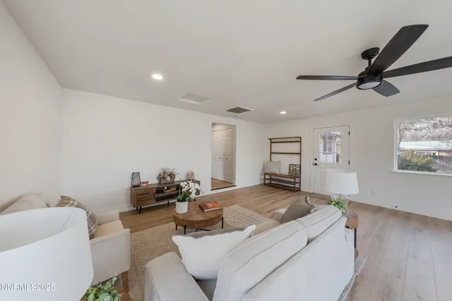 a living room with furniture and a ceiling fan