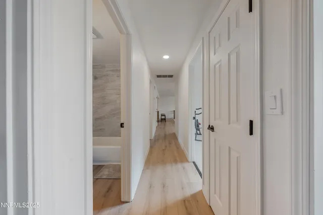 a view of a hallway with wooden floor and staircase