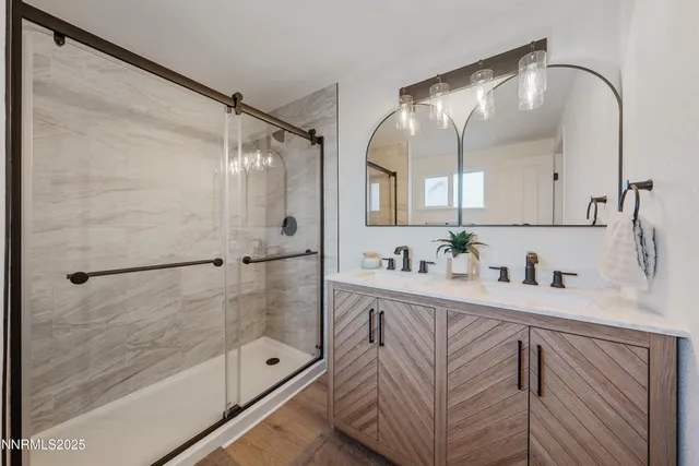 a bathroom with a granite countertop sink a mirror a shower and a bathtub