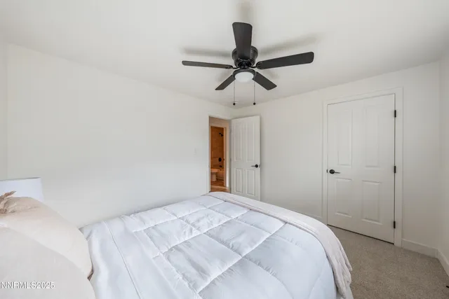 a bedroom with a bed and a chandelier fan
