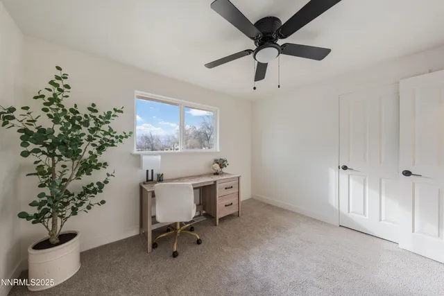 a workspace with a window and a ceiling fan