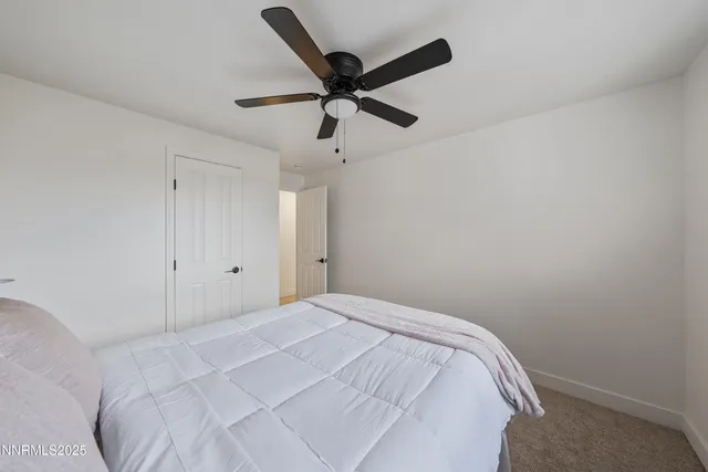 a bedroom with a bed and a ceiling fan