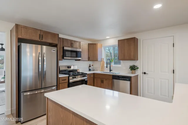 a kitchen with stainless steel appliances granite countertop a refrigerator stove a sink dishwasher and microwave oven