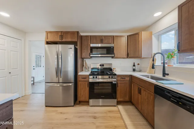 a kitchen with a refrigerator sink and wooden cabinets