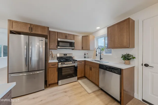 a kitchen with stainless steel appliances granite countertop a refrigerator stove microwave and sink