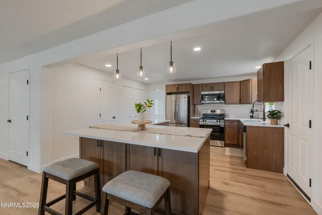 a kitchen with a dining table chairs and wooden floor