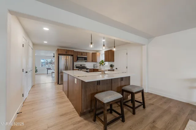 a kitchen with kitchen island stainless steel appliances a sink and cabinets