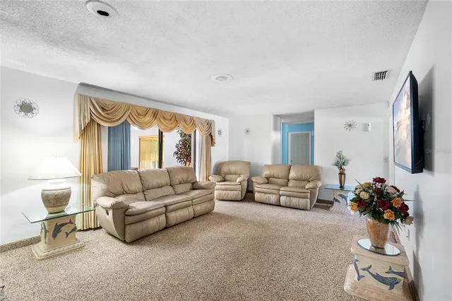 a living room with furniture flat screen tv and a large window
