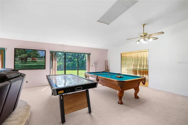 a room with furniture pool table and windows