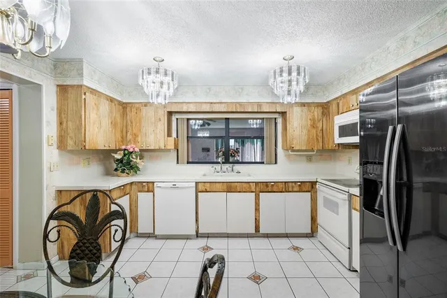a kitchen with stainless steel appliances granite countertop a sink and a refrigerator