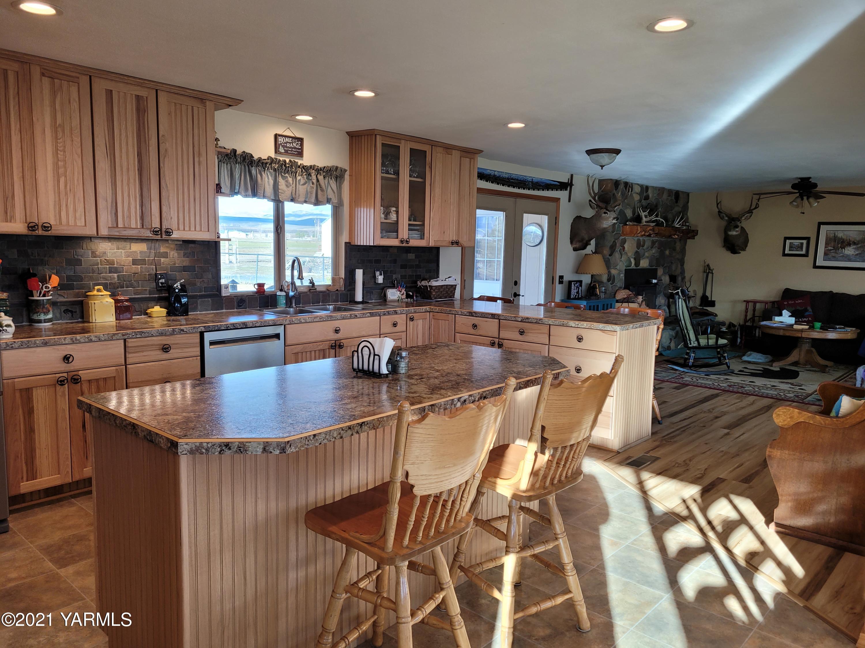 7773 North Wenas Road Selah, WA 98942 - Photo 14 of 45 a kitchen with stainless steel appliances granite countertop a table chairs sink and cabinets