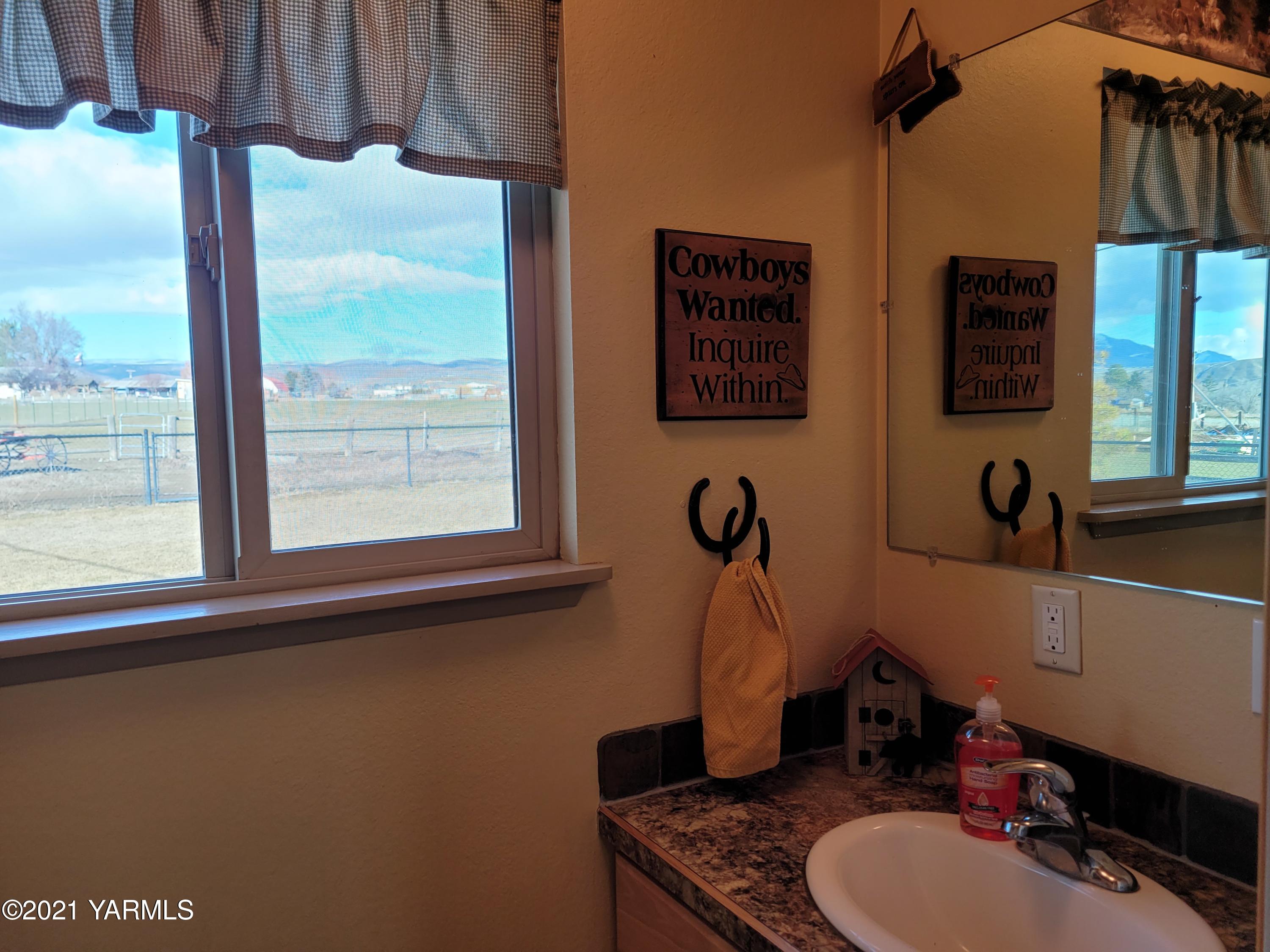 7773 North Wenas Road Selah, WA 98942 - Photo 19 of 45 a bathroom with a sink a toilet and a mirror