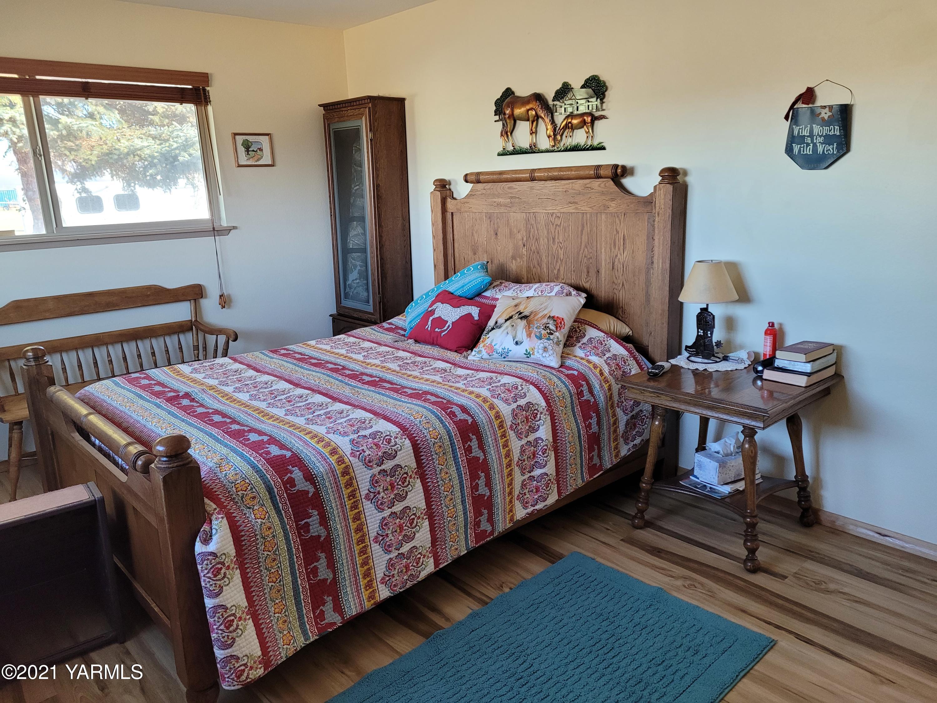 7773 North Wenas Road Selah, WA 98942 - Photo 26 of 45 a bedroom with a bed and wooden floor