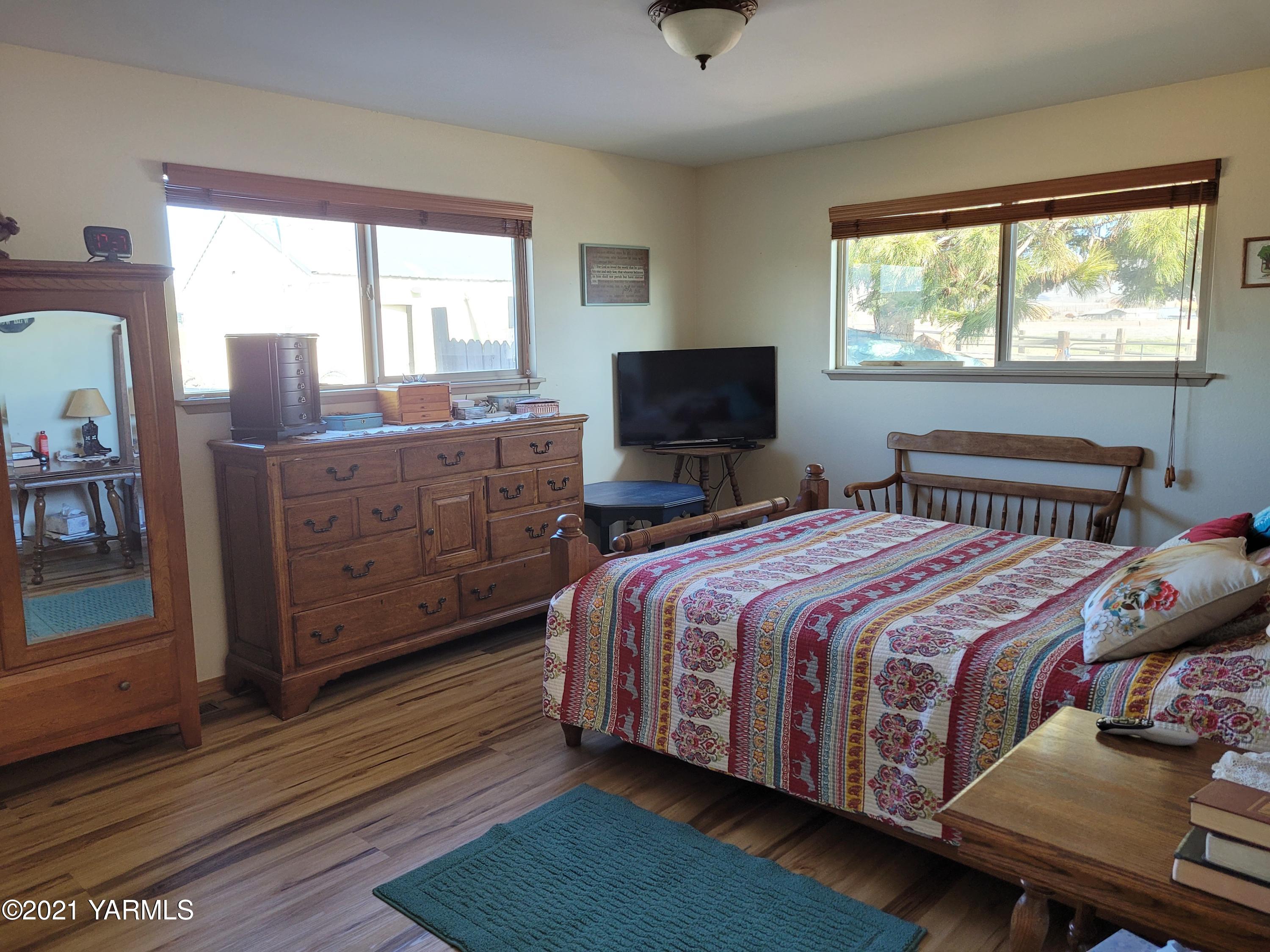 7773 North Wenas Road Selah, WA 98942 - Photo 27 of 45 a bedroom with a bed and wooden floor