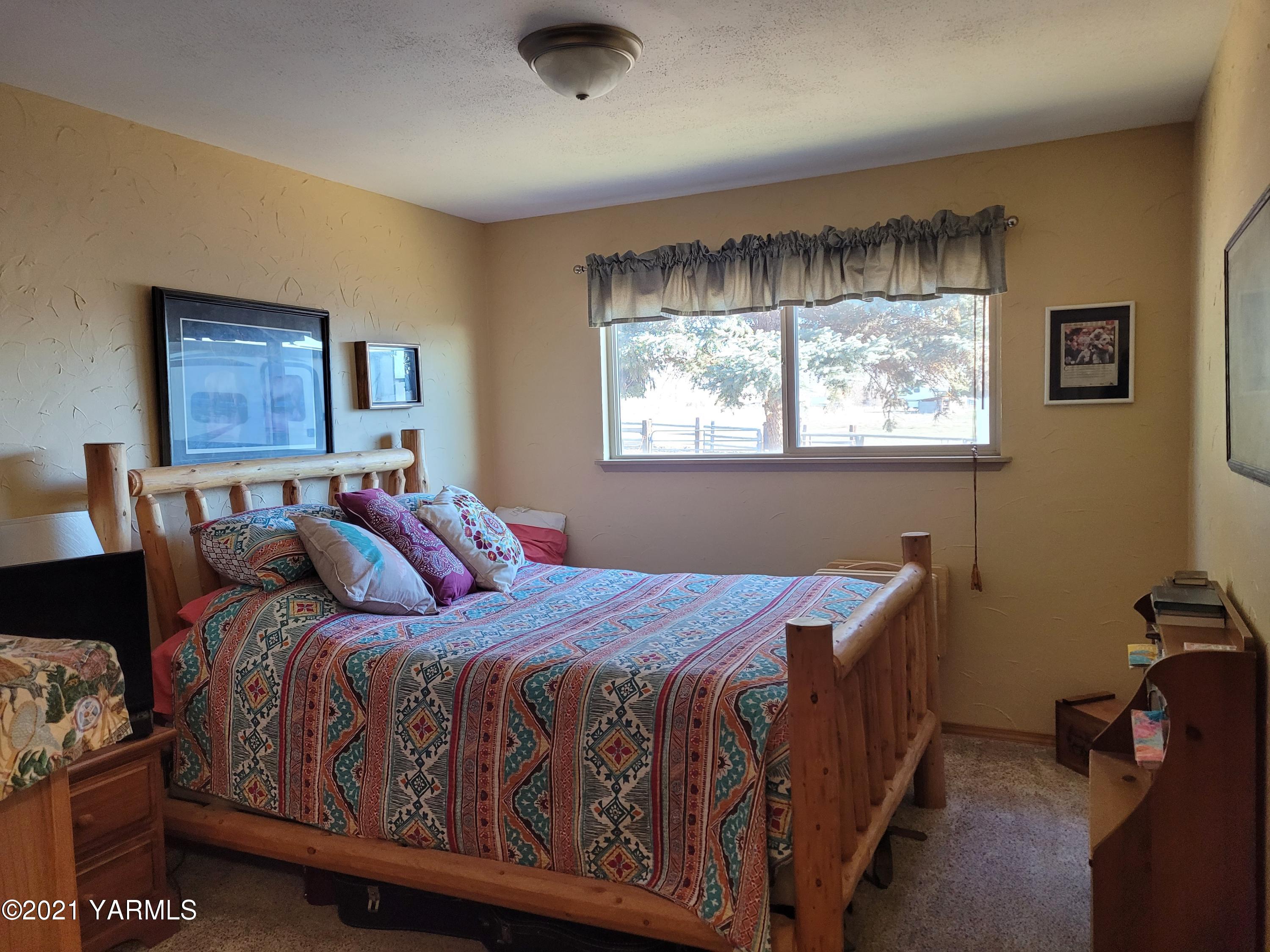7773 North Wenas Road Selah, WA 98942 - Photo 28 of 45 a bedroom with a bed and a window