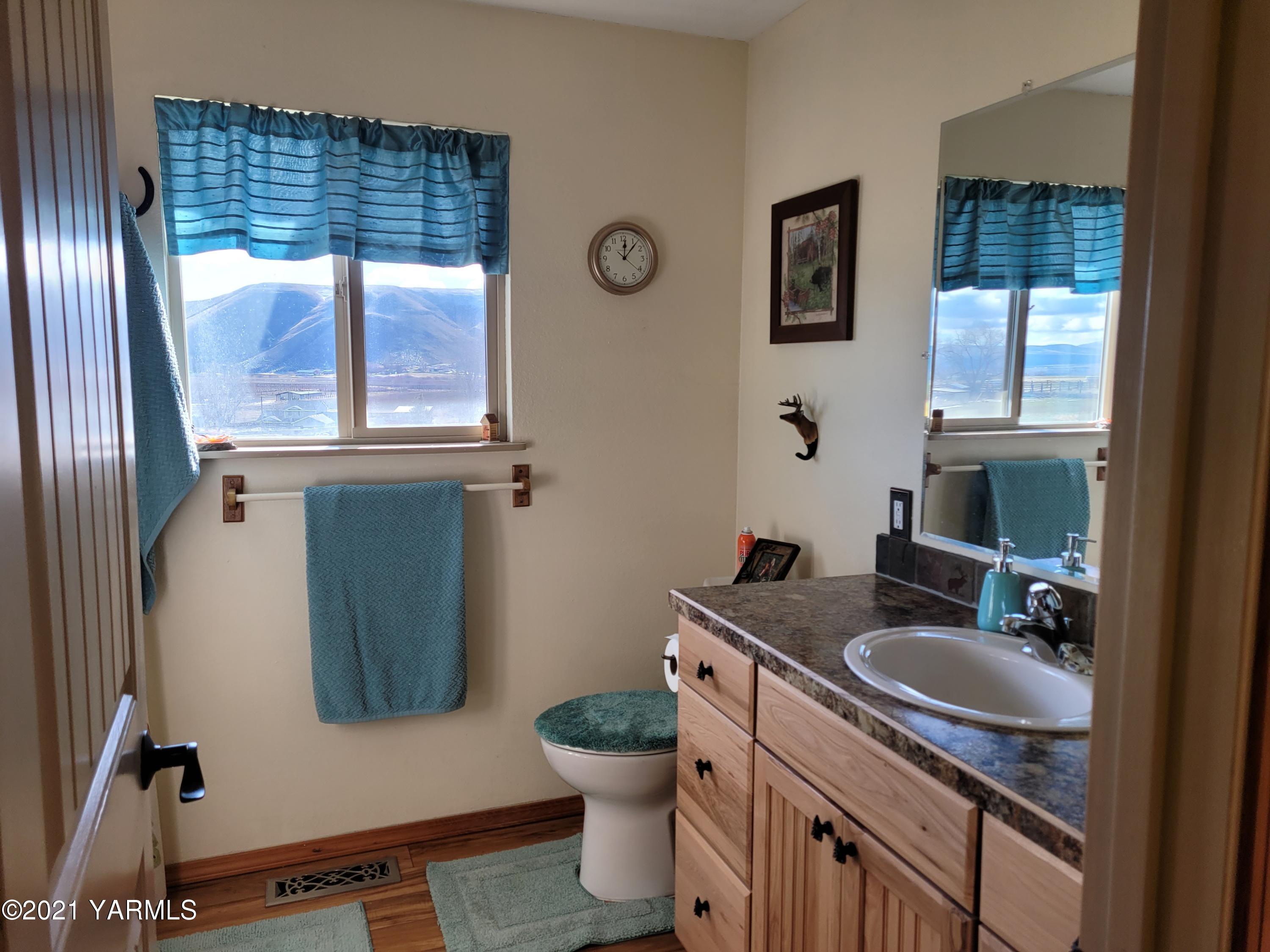 7773 North Wenas Road Selah, WA 98942 - Photo 29 of 45 a bathroom with a granite countertop toilet sink and mirror