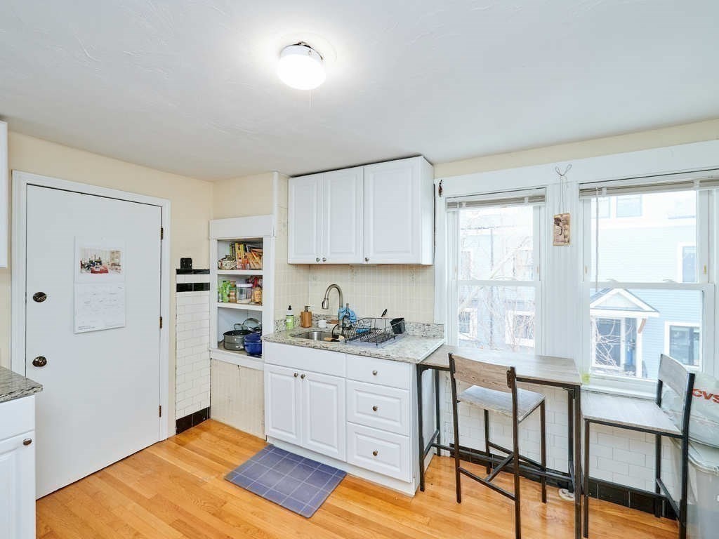 34 R Clyde Street Somerville, MA 02145 - Photo 20 of 31 a kitchen with white cabinets and window