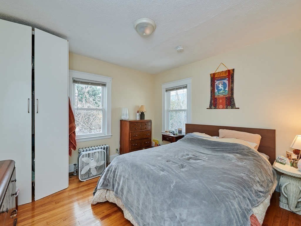 34 R Clyde Street Somerville, MA 02145 - Photo 23 of 31 a bedroom with a bed and a lamp on dresser
