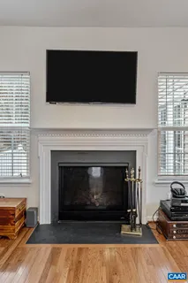 a living room with a fireplace a flat screen tv and a window