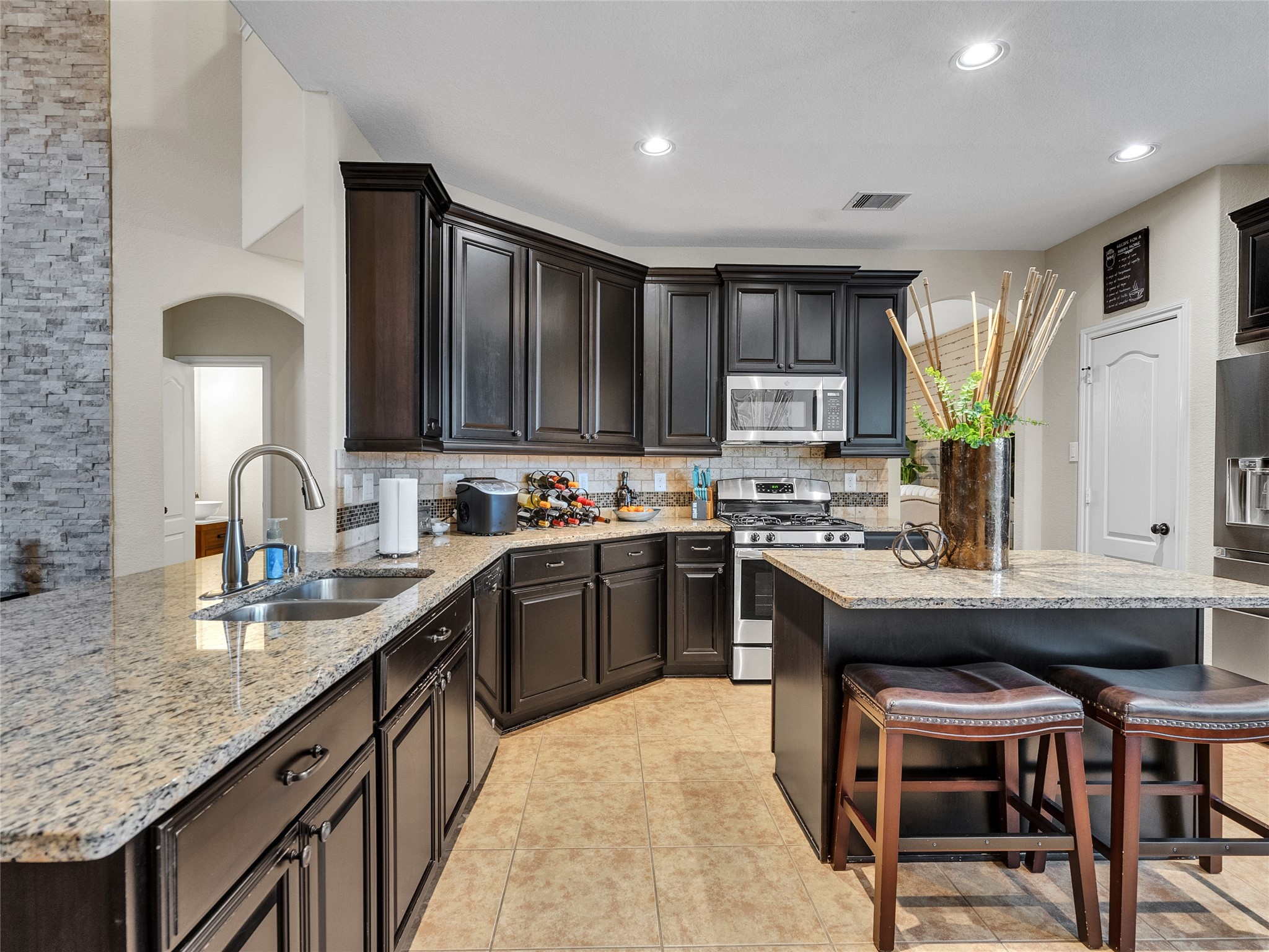 6530 Hunters Creek Lane Baytown, TX 77521 - Photo 9 of 40 a kitchen with kitchen island granite countertop a sink counter top space appliances and cabinets