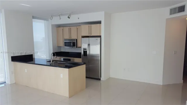a kitchen with stainless steel appliances a refrigerator and a stove top oven