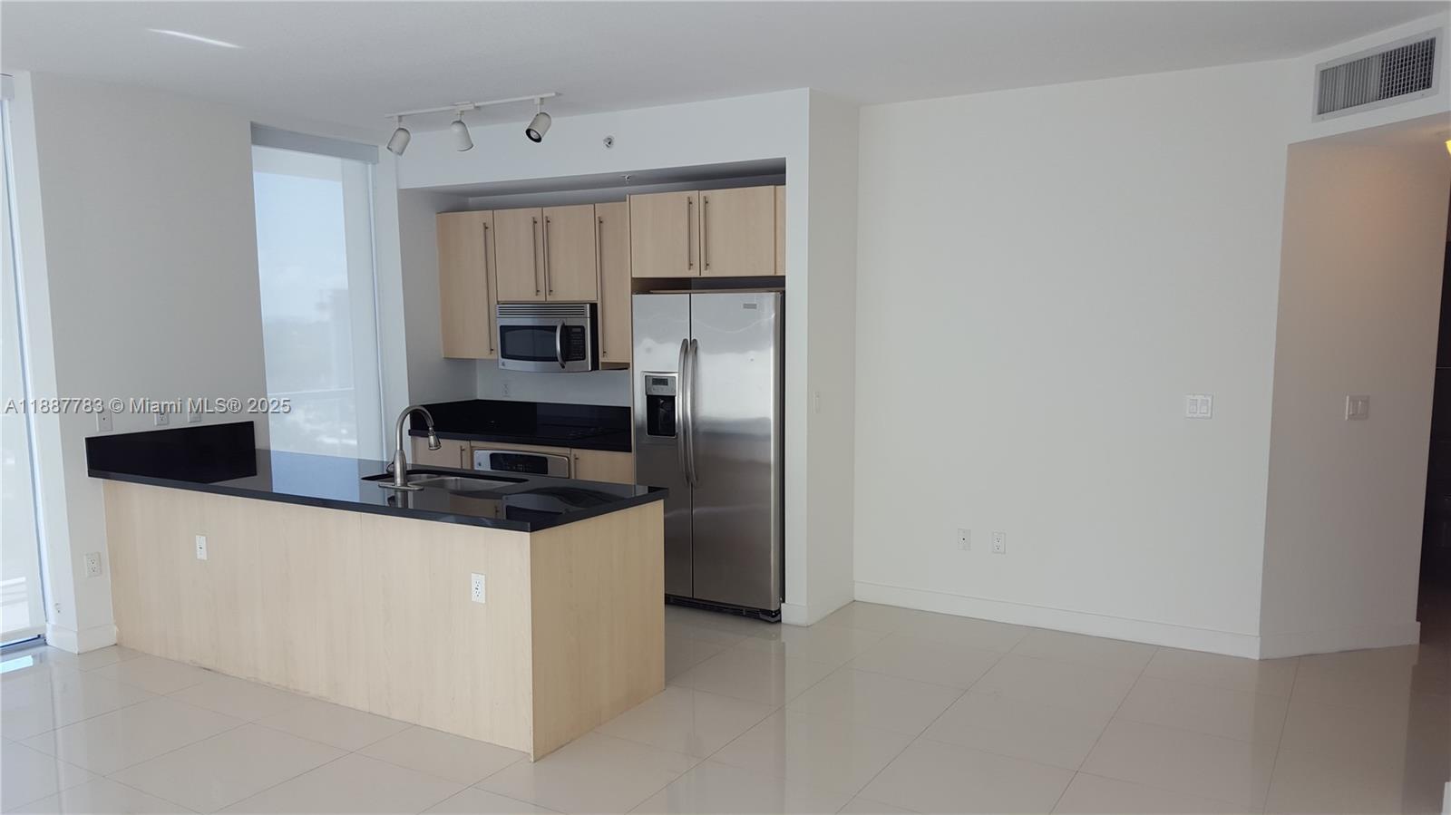 79 Southwest 12th Street, Unit 1506S Miami, FL 33130 - Photo 2 of 6 a kitchen with stainless steel appliances a refrigerator and a stove top oven