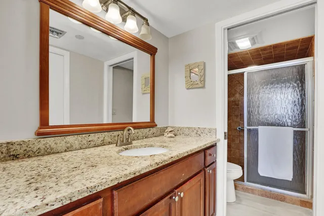 a bathroom with a granite countertop sink and a mirror