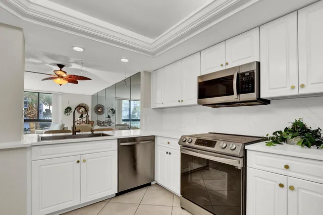 a kitchen with stainless steel appliances granite countertop white cabinets a sink and dishwasher