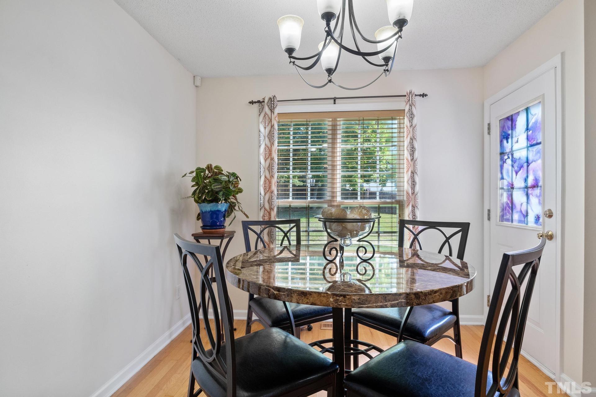 4213 Somerset Valley Lane Raleigh, NC 27616 - Photo 12 of 31 a view of a dining room with furniture wooden floor and a chandelier