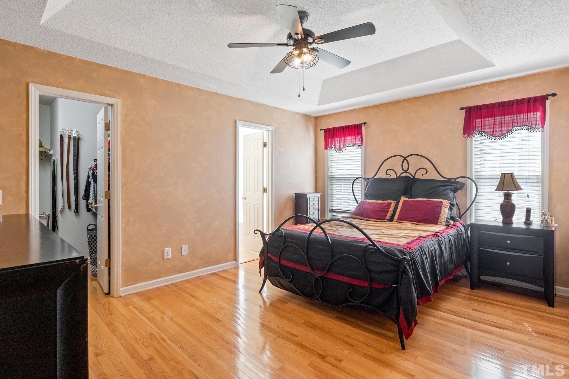 4213 Somerset Valley Lane Raleigh, NC 27616 - Photo 28 of 31 a bedroom with a bed and dresser with wooden floor