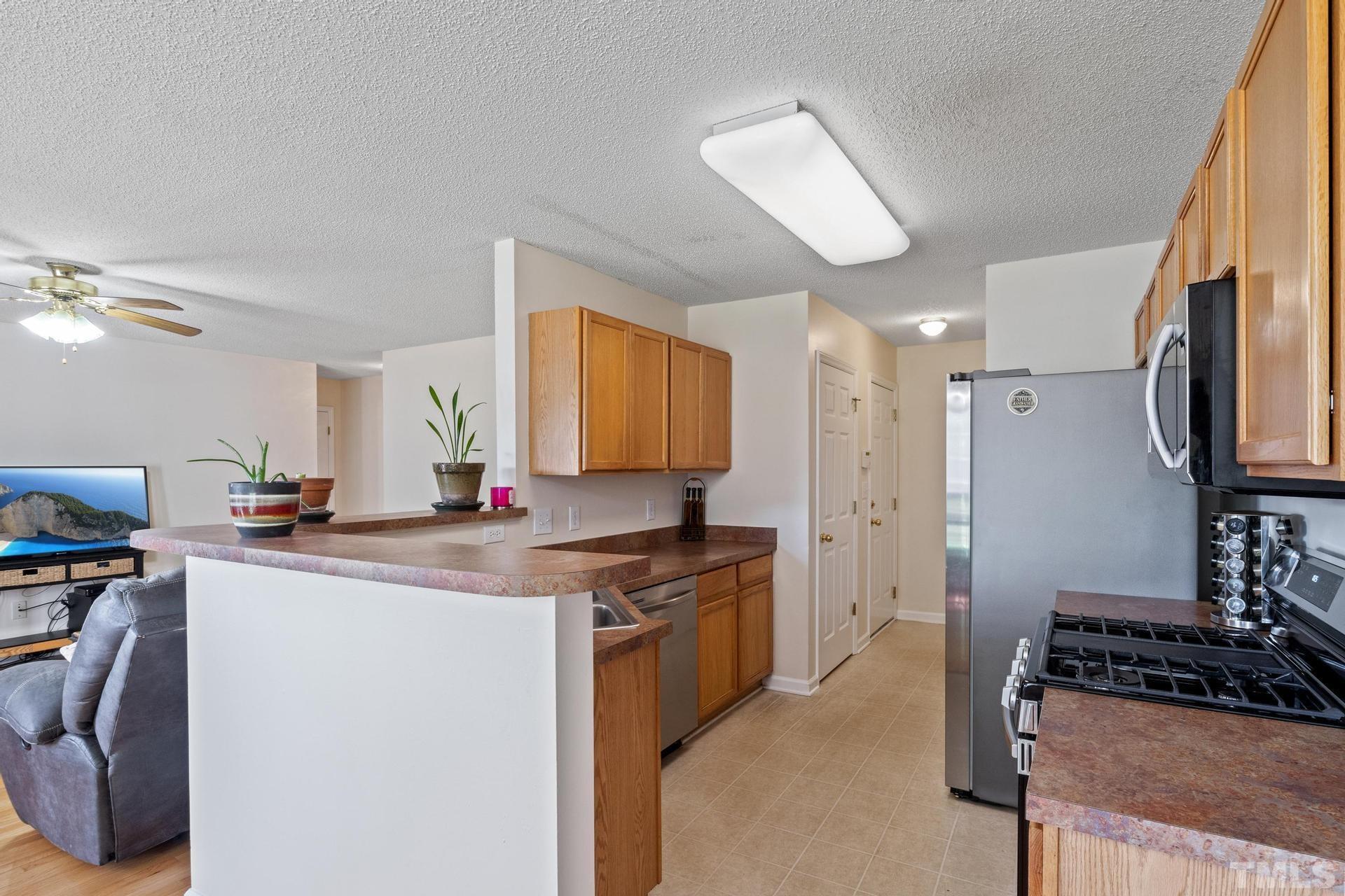 4213 Somerset Valley Lane Raleigh, NC 27616 - Photo 6 of 31 a kitchen with a stove a refrigerator and a sink
