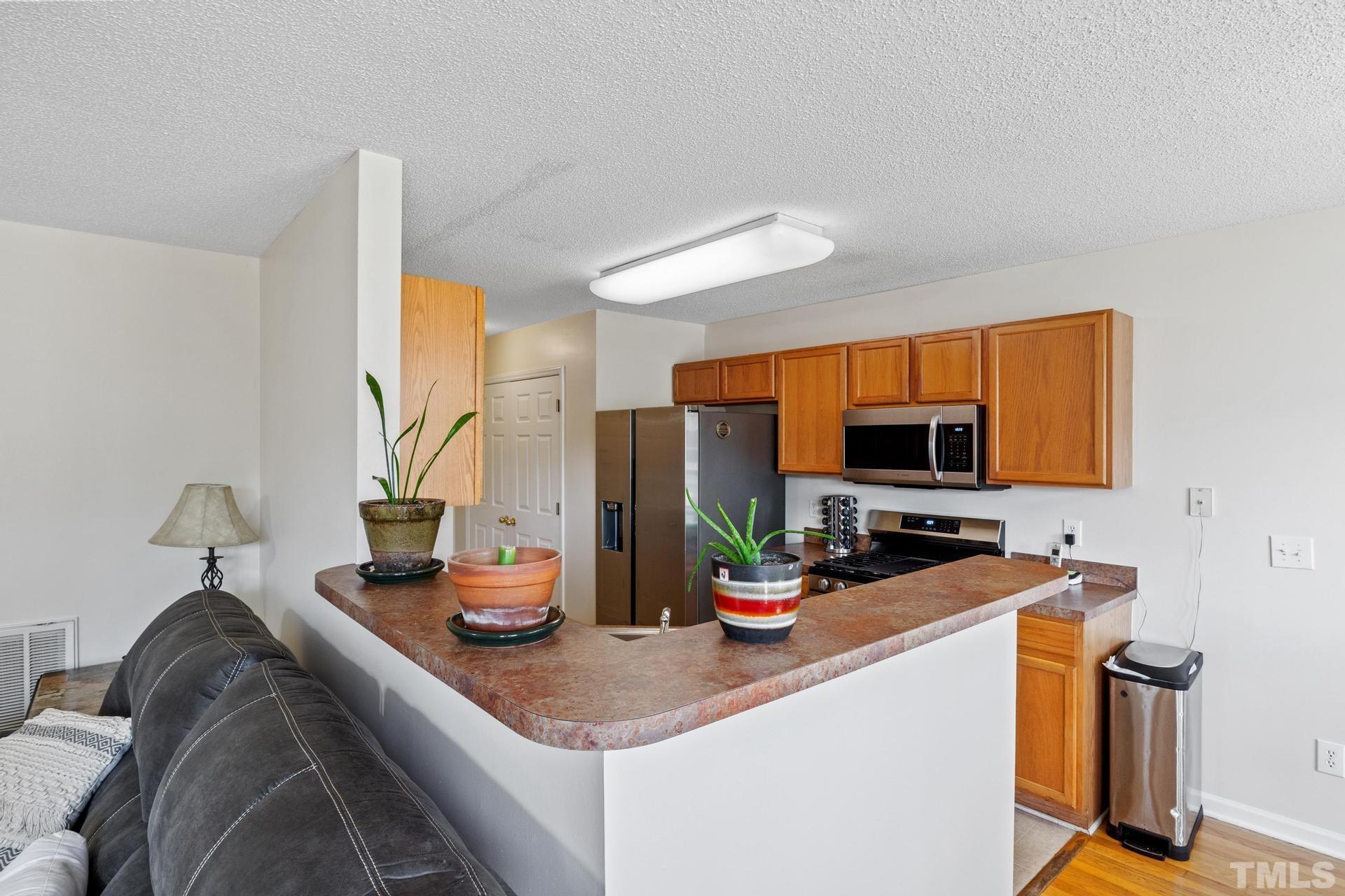 4213 Somerset Valley Lane Raleigh, NC 27616 - Photo 7 of 31 a kitchen with a sink and a stove top oven
