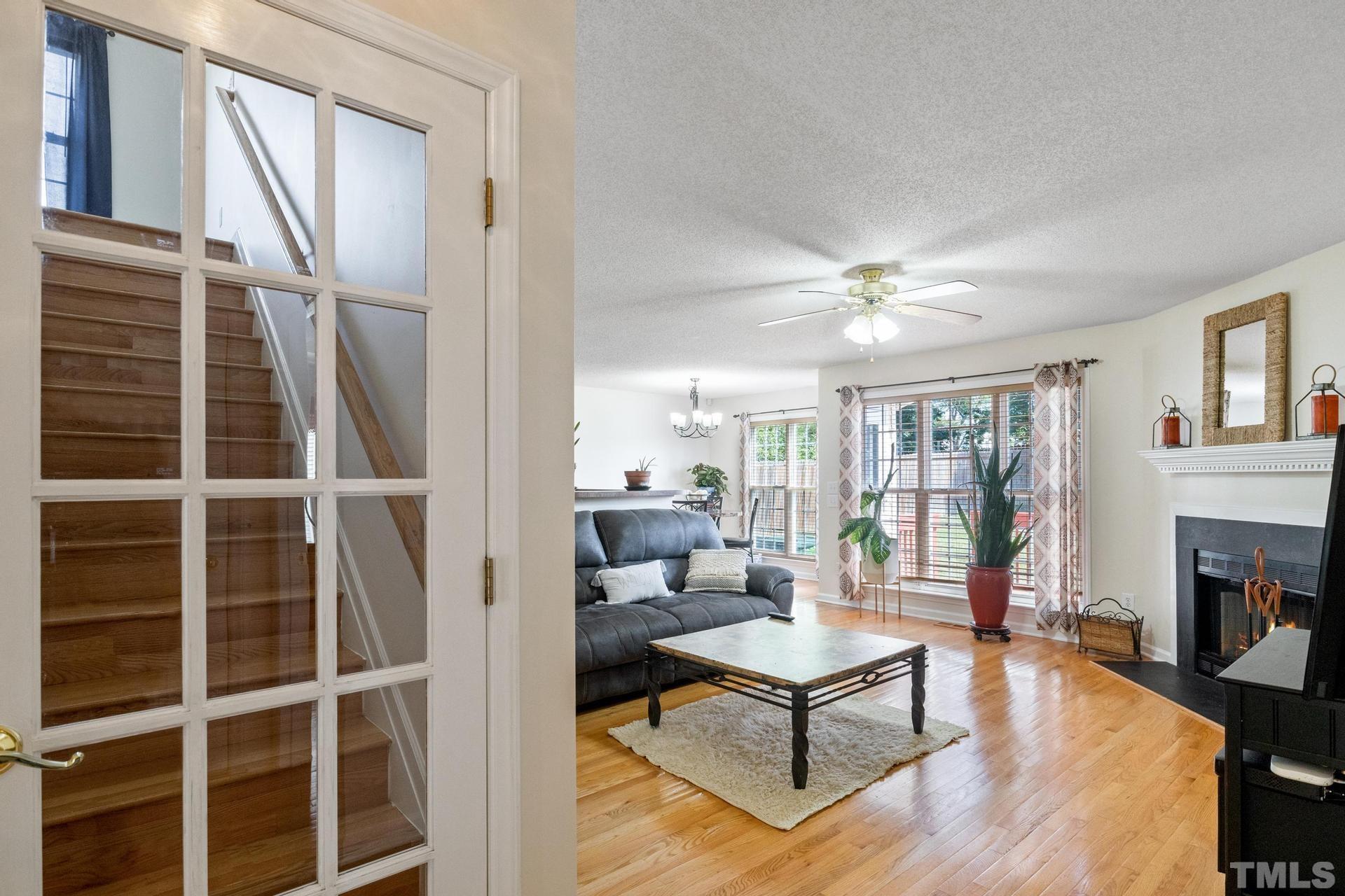 4213 Somerset Valley Lane Raleigh, NC 27616 - Photo 9 of 31 a living room with furniture a fireplace and a floor to ceiling window