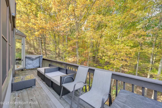 a balcony with wooden floor and outdoor seating
