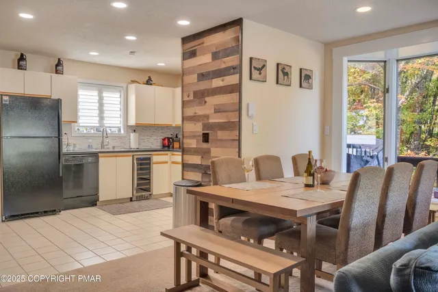 a kitchen with a refrigerator a stove a sink dishwasher with a dining table and chairs