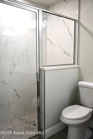 a bathroom with a toilet and a shower curtain