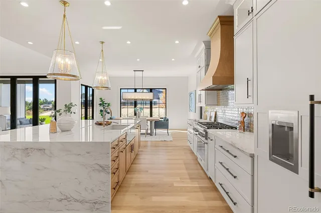 a kitchen with stainless steel appliances kitchen island granite countertop a table chairs and a stove