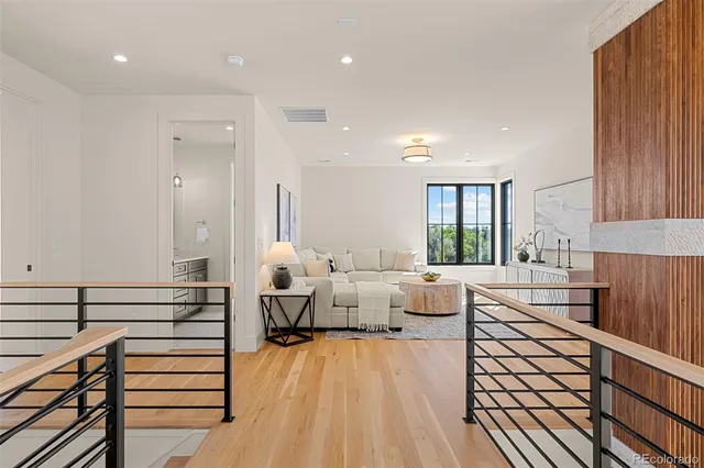 a kitchen with stainless steel appliances granite countertop a table chairs in it and wooden floors