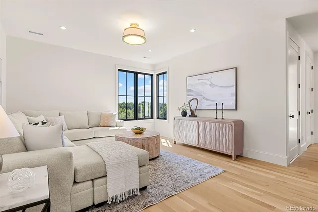 a living room with furniture and a wooden floor