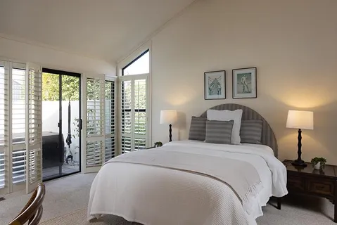 a bedroom with a balcony a bed and a lamp