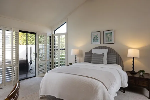 a bedroom with a balcony a bed and a lamp