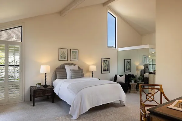 a bedroom with a bed and lamp with window