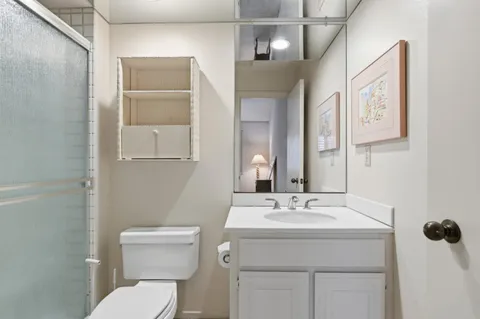 a bathroom with a toilet sink and mirror